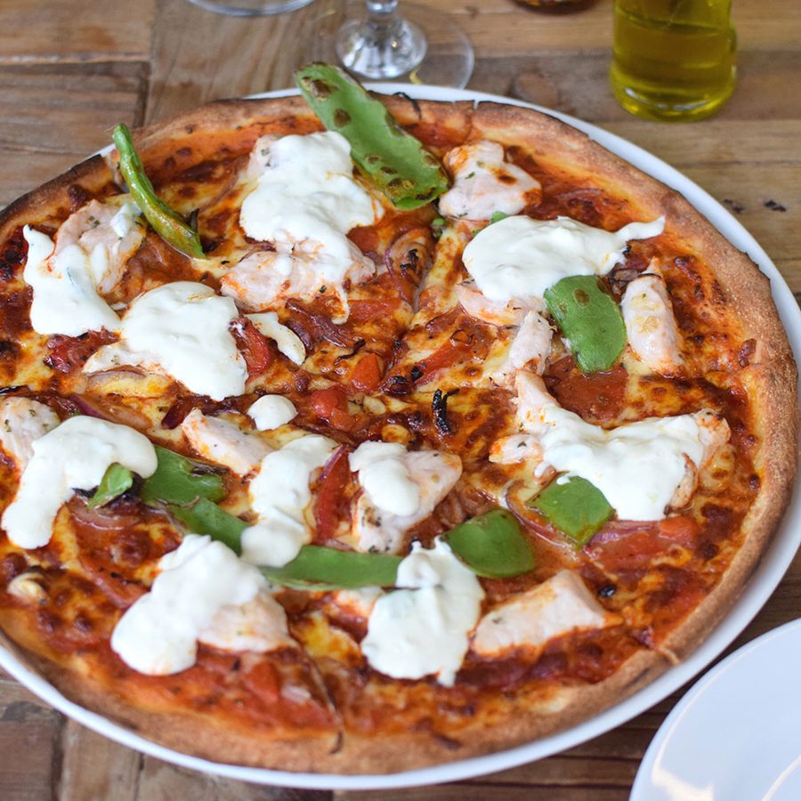 Pizza topped with torn mozzarella and fresh basil