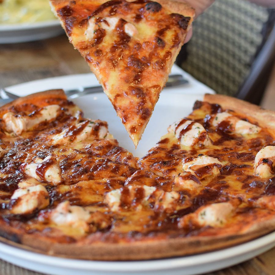 A slice being lifted from a freshly baked pizza
