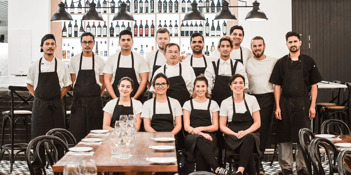 The Lucky and Pep's team standing together in aprons in the restaurant dining room