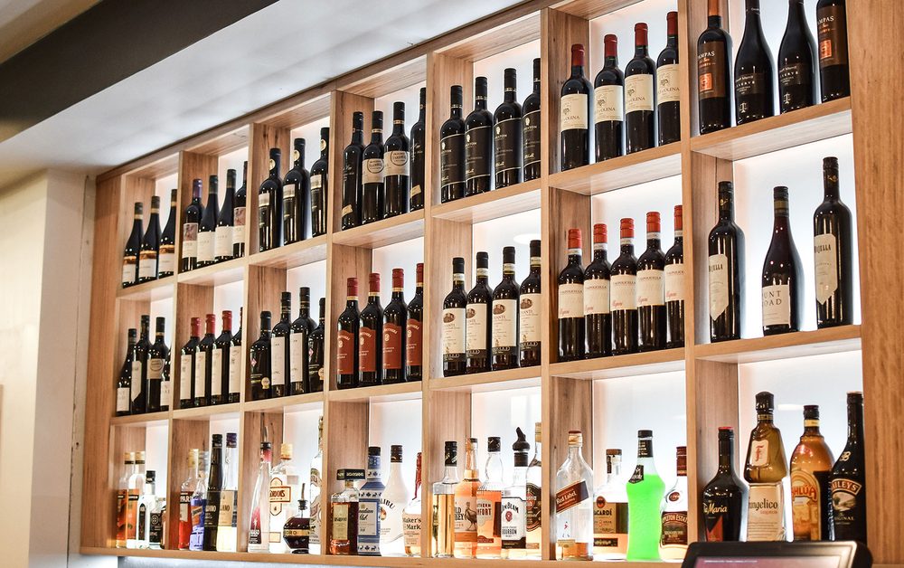 Shelves of wine bottles lining the wall behind the bar